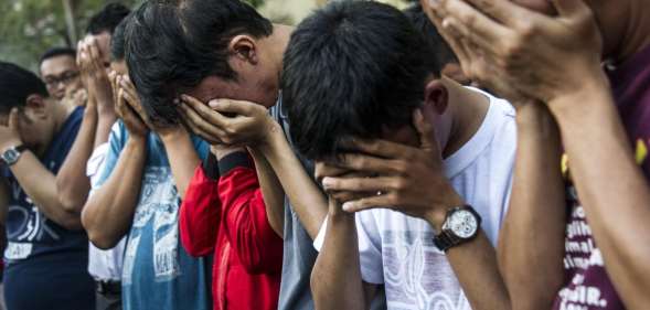 Indonesian police parade a group of men arrested for holding a "gay party" in Surabaya