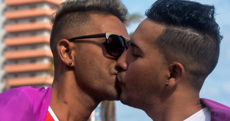 A gay couple kiss in the pride parade during the celebration of the day against homophobia and transphobia in Havana, on May 13, 2017. / AFP PHOTO / STR (Photo credit should read STR/AFP/Getty Images)