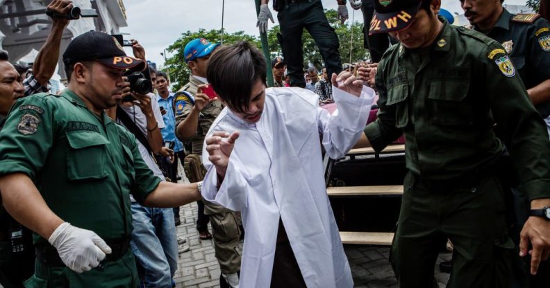 Indonesian man escorted after public caning for having gay sex BANDA ACEH, INDONESIA - MAY 23: An indonesian man escorted by the sharia police after get caning in public from an executor known as 'algojo' for having gay sex, which is against Sharia law at Syuhada mosque on May 23, 2017 in Banda Aceh, Indonesia. The two young gay men, aged 20 and 23, were caned 85 times each in the Indonesian province of Aceh during a public ceremony after being caught having sex last week. It was the first time gay men have been caned under Sharia law as gay sex is not illegal in most of Indonesia except for Aceh, which is the only province which exercises Islamic law. The punishment came a day after the police arrested 141 men at a sauna in the capital Jakarta on Monday due to suspicion of having a gay sex party, the latest crackdown on homosexuality in the country. (Photo by Ulet Ifansasti/Getty Images)