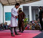 BANDA ACEH, INDONESIA - MAY 23: An acehnese man gets caning in public from an executor known as 'algojo' for spending time with a woman who is not his wife, which is against Sharia law at Syuhada mosque on May 23, 2017 in Banda Aceh, Indonesia. Indonesia's Aceh Province, on the northern tip of Sumatra island, is among the only place in the Muslim-majority country which implements the strict version of Sharia Law. Public canings take place regularly in Aceh for a range of offenses from adultery to homosexuality to selling alcohol, while women are required to dress modestly and Shariah police officers patrol the streets and conduct raids to hunt for immoral activities. More than 90 per cent of the 255 million people who live in Indonesia describe themselves as Muslim, but the vast majority practice a moderate form. According to reports, the Shariah Law in Aceh began in 2001, after receiving authorization from Indonesia's central government, which was intent on calming separatist sentiment in the conservative region while today. (Photo by Ulet Ifansasti/Getty Images)