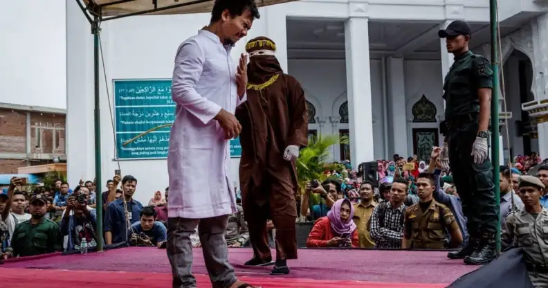BANDA ACEH, INDONESIA - MAY 23: An acehnese man gets caning in public from an executor known as 'algojo' for spending time with a woman who is not his wife, which is against Sharia law at Syuhada mosque on May 23, 2017 in Banda Aceh, Indonesia. Indonesia's Aceh Province, on the northern tip of Sumatra island, is among the only place in the Muslim-majority country which implements the strict version of Sharia Law. Public canings take place regularly in Aceh for a range of offenses from adultery to homosexuality to selling alcohol, while women are required to dress modestly and Shariah police officers patrol the streets and conduct raids to hunt for immoral activities. More than 90 per cent of the 255 million people who live in Indonesia describe themselves as Muslim, but the vast majority practice a moderate form. According to reports, the Shariah Law in Aceh began in 2001, after receiving authorization from Indonesia's central government, which was intent on calming separatist sentiment in the conservative region while today. (Photo by Ulet Ifansasti/Getty Images)
