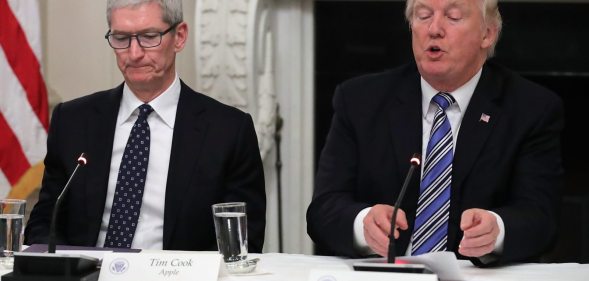 WASHINGTON, DC - JUNE 19: Apple CEO Tim Cook listens to U.S. President Donald Trump deliver opening remarks during a meeting of the American Technology Council in the State Dining Room of the White House June 19, 2017 in Washington, DC. According to the White House, the council's goal is "to explore how to transform and modernize government information technology." (Photo by Chip Somodevilla/Getty Images)