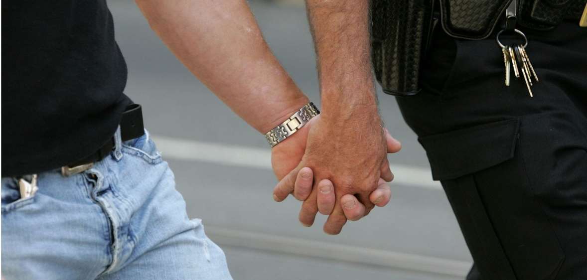 A same-sex couple holding hands, representing the gay couples who met online