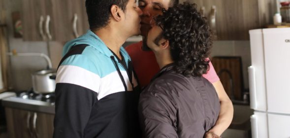 Manuel Bermudez (L), Alejandro Rodriguez (C) and Victor Prada give each other a kiss at their home in Medellin, Colombia on June 17, 2017. The three men have gained legal recognition as the first "polyamorous family" in the country , where same-sex marriages were legalized last year. / AFP PHOTO / JOAQUIN SARMIENTO (Photo credit should read JOAQUIN SARMIENTO/AFP/Getty Images)