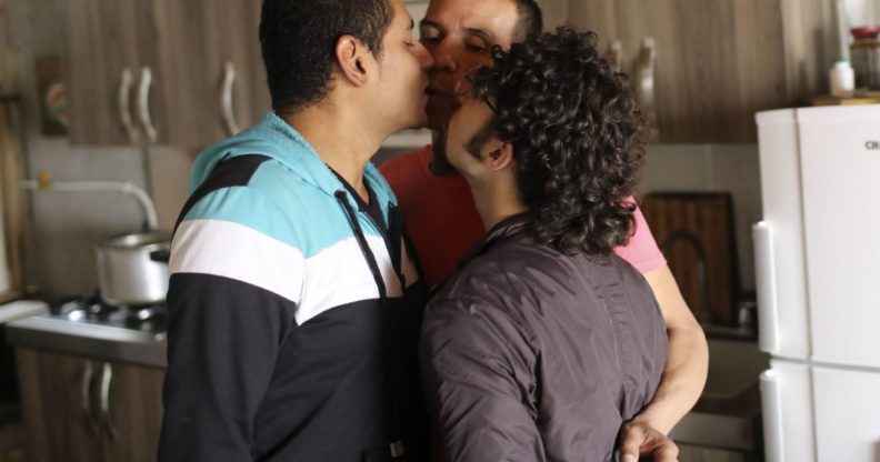 Manuel Bermudez (L), Alejandro Rodriguez (C) and Victor Prada give each other a kiss at their home in Medellin, Colombia on June 17, 2017. The three men have gained legal recognition as the first "polyamorous family" in the country , where same-sex marriages were legalized last year. / AFP PHOTO / JOAQUIN SARMIENTO (Photo credit should read JOAQUIN SARMIENTO/AFP/Getty Images)
