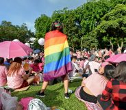 A supporter wrapped in a rainbow flag attends the annual "Pink Dot" event in a public show of support for the LGBT community at Hong Lim Park in Singapore on July 1, 2017. Thousands of Singaporeans took part in the gay-rights rally on July 1. / AFP PHOTO / Roslan RAHMAN (Photo credit should read ROSLAN RAHMAN/AFP/Getty Images)