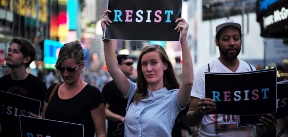 Protesters display placards against US President Donald Trump during a demonstration in front of the US Army career center in Times Square, New York, on July 26, 2017. Trump announced on July 26 that transgender people may not serve "in any capacity" in the US military, citing the "tremendous medical costs and disruption" their presence would cause. / AFP PHOTO / Jewel SAMAD (Photo credit should read JEWEL SAMAD/AFP/Getty Images)