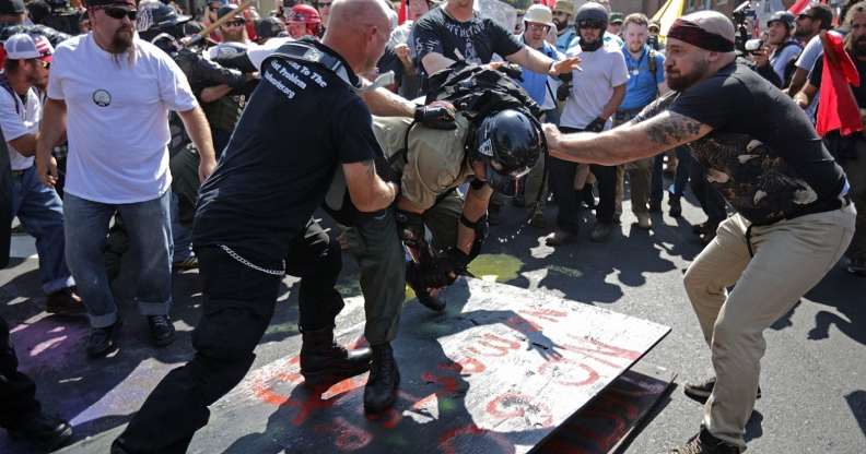 CHARLOTTESVILLE, VA - AUGUST 12: White nationalists, neo-Nazis, the KKK and members of the "alt-right" attack each other as a counter protester (R) intervenes during the melee outside Emancipation Park during the Unite the Right rally August 12, 2017 in Charlottesville, Virginia. After clashes with anti-fascist protesters and police the rally was declared an unlawful gathering and people were forced out of Lee Park, where a statue of Confederate General Robert E. Lee is slated to be removed. (Photo by Chip Somodevilla/Getty Images)