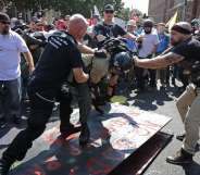 CHARLOTTESVILLE, VA - AUGUST 12: White nationalists, neo-Nazis, the KKK and members of the "alt-right" attack each other as a counter protester (R) intervenes during the melee outside Emancipation Park during the Unite the Right rally August 12, 2017 in Charlottesville, Virginia. After clashes with anti-fascist protesters and police the rally was declared an unlawful gathering and people were forced out of Lee Park, where a statue of Confederate General Robert E. Lee is slated to be removed. (Photo by Chip Somodevilla/Getty Images)