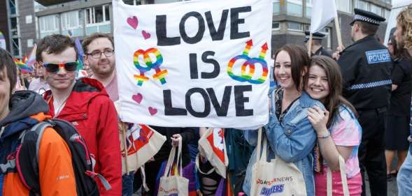 People hold up a sign during Glasgow Pride.