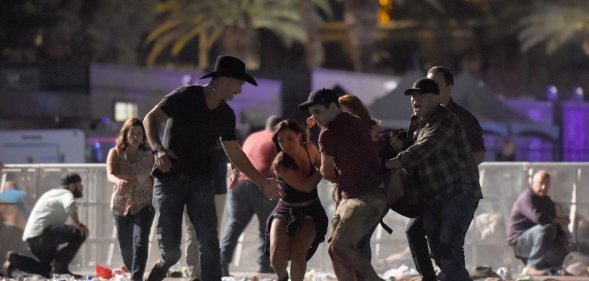 LAS VEGAS, NV - OCTOBER 01: (EDITORS NOTE: Image contains graphic content.) People carry a peson at the Route 91 Harvest country music festival after apparent gun fire was heard on October 1, 2017 in Las Vegas, Nevada. There are reports of an active shooter around the Mandalay Bay Resort and Casino. (Photo by David Becker/Getty Images)