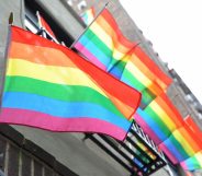 LGBT+ Pride flags flutter in the breeze from a building