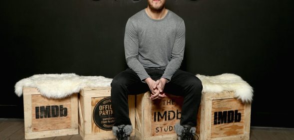 Singer Dan Reynolds sits on a box.
