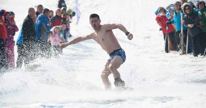 HARBIN, CHINA - MARCH 24: A man strip to the waist during the Naked Pig Skiing Carnival at the Yabuli Ski Resort on March 24, 2018 in Harbin of Heilongjiang Province, northeast China. Men stripped to the waist and women wearing swim suits attended the carnival which is held to promote skiing. (Photo by Tao Zhang/Getty Images)
