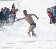 HARBIN, CHINA - MARCH 24: A man strip to the waist during the Naked Pig Skiing Carnival at the Yabuli Ski Resort on March 24, 2018 in Harbin of Heilongjiang Province, northeast China. Men stripped to the waist and women wearing swim suits attended the carnival which is held to promote skiing. (Photo by Tao Zhang/Getty Images)