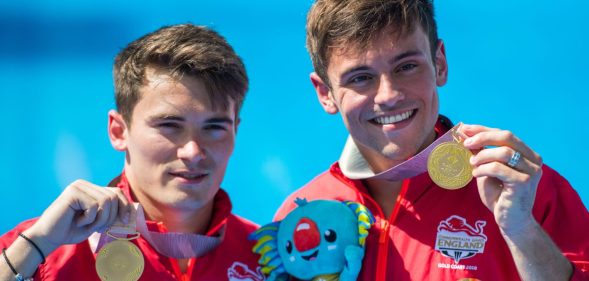 England's Thomas Daley (R) and Daniel Goodfellow pose with their gold medals after the men's synchronised 10m platform diving in the 2018 Gold Coast Commonwealth Games at the Optus Aquatic Centre on the Gold Coast on April 13, 2018 / AFP PHOTO / François-Xavier MARIT / The erroneous mention[s] appearing in the metadata of this photo by François-Xavier MARIT has been modified in AFP systems in the following manner: [gold medals] instead of [silver medals (as previously corrected)]. Please immediately remove the erroneous mention[s] from all your online services and delete it (them) from your servers. If you have been authorized by AFP to distribute it (them) to third parties, please ensure that the same actions are carried out by them. Failure to promptly comply with these instructions will entail liability on your part for any continued or post notification usage. Therefore we thank you very much for all your attention and prompt action. We are sorry for the inconvenience this notification may cause and remain at your disposal for any further information you may require. (Photo credit should read FRANCOIS-XAVIER MARIT/AFP/Getty Images)