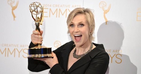 Jane Lynch holding an Emmy Award