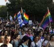 Participants wave Israeli and LGBT pride rainbow flags during Jerusalem's annual Gay Pride parade on August 2, 2018.