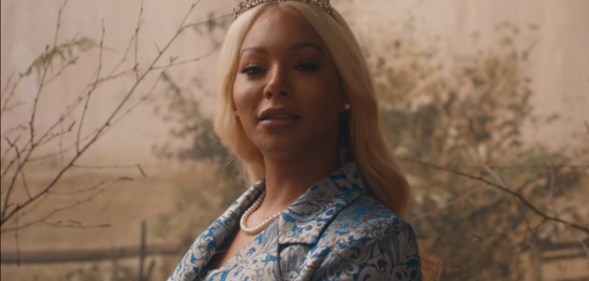 Munroe Bergdorf wearing red sunglasses and purple lipstick