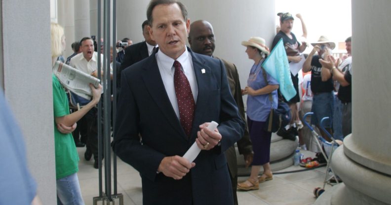 MONTGOMERY, AL ? AUGUST 21: Alabama Supreme Court Chief Justice Roy Moore walks back into the state Judicial Building after addressing supporters August 21, 2003 in Montgomery, Alabama. The eight other justices today overruled Moore?s defiance of a federal court order to remove a 5,300 lb granite monument of the Ten Commandments that is exhibited in the Judicial Building. Moore defied a deadline to get rid of the monument by midnight today. The U.S. Supreme Court declined to consider the issue Wednesday. (Photo by Gary Tramontina/Getty Images)