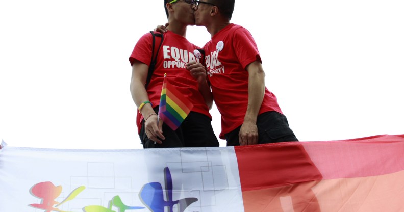 A gay couple kiss at an anti-discrimination parade in Chine, where a writer was recently jailed for including gay sex scenes in her novel.