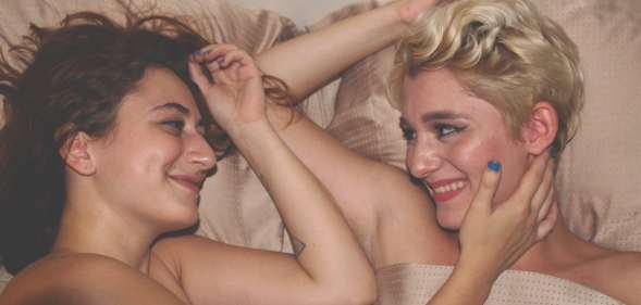 Women looking satisfied in bed, which according to LGBT+ science is normal for women who have sex with women.