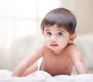 A baby crawling on a blanket. (Creative Commons)
