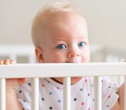 Baby boy standing in crib