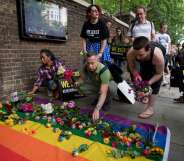Demonstrators lay roses on a rainbow flag as they protest over an alleged crackdown on gay men in Chechnya