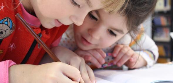 Two children draw a picture together, similar to the images Russian Police seized from a school.