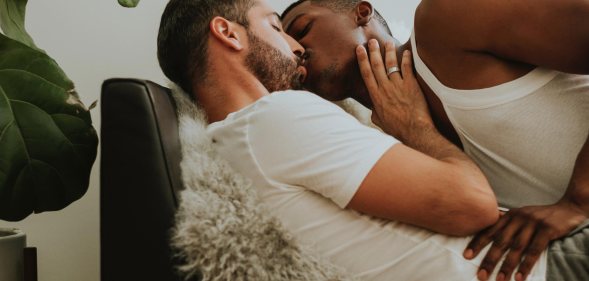 Two men kissing on a couch