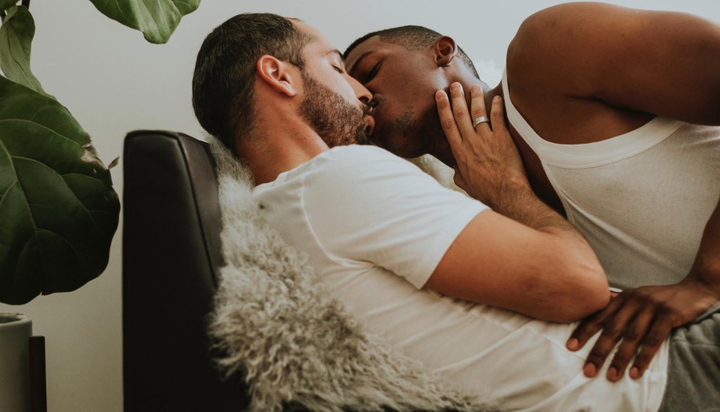 Two men kissing on a couch