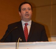 Jason Kenney speaking into a microphone