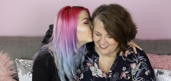 Lesbian couple Julia and Eileen kiss on the sofa