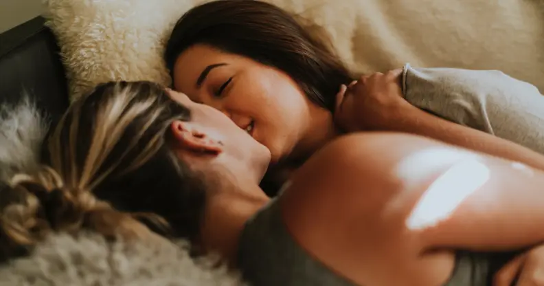 Two women embrace in bed
