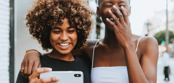 Two women smile while taking a photo of themselves