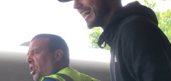 A man wearing a hi-vis vest and a man in a black cap