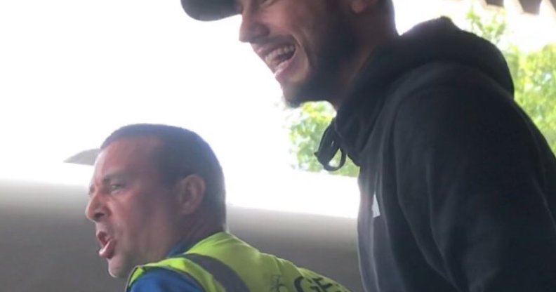 A man wearing a hi-vis vest and a man in a black cap