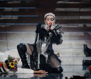 Madonna kneeling on stage wearing her Madame X eyepatch