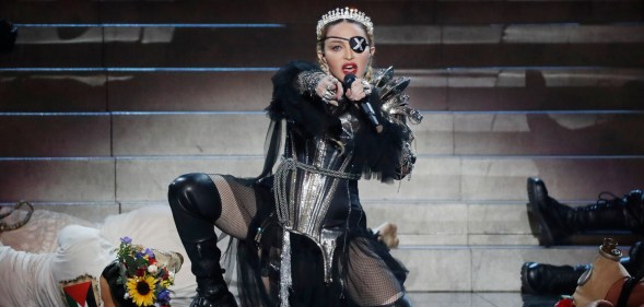 Madonna kneeling on stage wearing her Madame X eyepatch