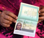 A close up of hands holding a non-binary passport.