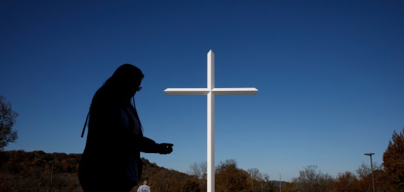 A silhouette against a white church cross