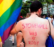 A topless man with 'Stonewall was a riot' written on his back