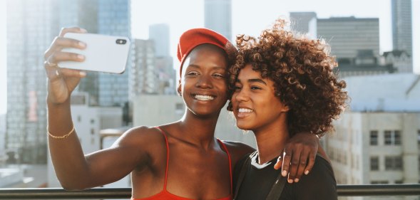 Black queer lesbian women using phone for lesbian dating apps