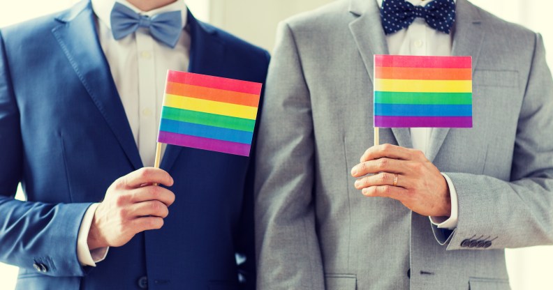 gay men hold up pride flags