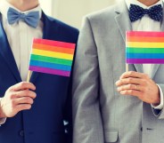 gay men hold up pride flags