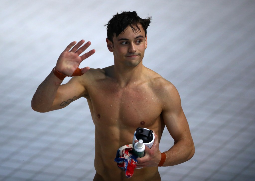 Tom Daley shirtless and waving