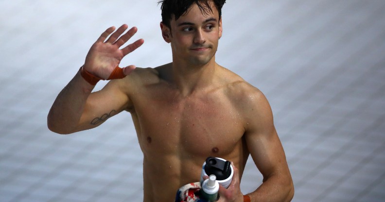 Tom Daley shirtless and waving