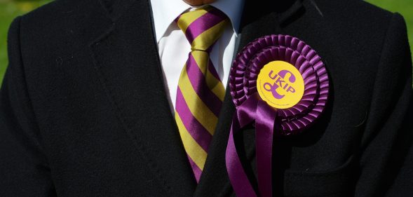 A voter wears a UK Independence Party (UKIP) rosette as he stands outside a polling station in Brighton, southern England on May 7, 2015, as Britain holds a general election. Polls opened Thursday in Britain's closest general election for decades with voters set to decide between the Conservatives of Prime Minister David Cameron, Ed Miliband's Labour and a host of smaller parties. AFP PHOTO / GLYN KIRK (Photo credit should read GLYN KIRK/AFP/Getty Images)