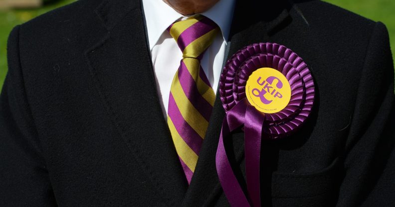 A voter wears a UK Independence Party (UKIP) rosette as he stands outside a polling station in Brighton, southern England on May 7, 2015, as Britain holds a general election. Polls opened Thursday in Britain's closest general election for decades with voters set to decide between the Conservatives of Prime Minister David Cameron, Ed Miliband's Labour and a host of smaller parties. AFP PHOTO / GLYN KIRK (Photo credit should read GLYN KIRK/AFP/Getty Images)